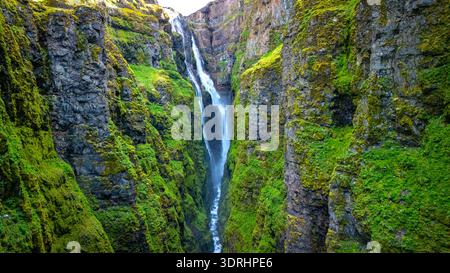 Der Glymur-Wasserfall stürzt über üppig grüne Klippen in der malerischen Landschaft Islands Stockfoto