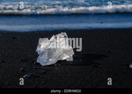 Atemberaubende Eisformationen glitzern auf dem schwarzen Sand von Diamond Beach in Island Stockfoto