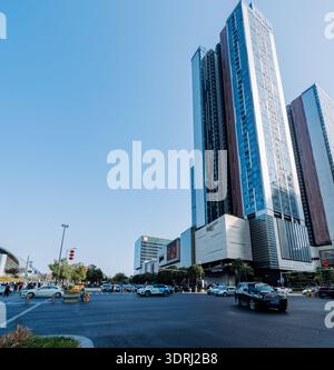 Moderne Wolkenkratzer dominieren das Stadtbild mit belebtem Straßenverkehr unter klarem blauem Himmel Stockfoto