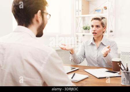 Besprechung zwischen zwei Kollegen, die ein Projekt in einer Büroumgebung während der Tageszeiten diskutieren Stockfoto