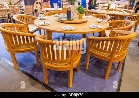 Hölzerner Esstisch mit rundem Tisch und passenden Stühlen in gemütlicher Umgebung Stockfoto