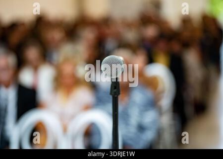Nahaufnahme des Mikrofons vor dem Publikum bei einer Indoor-Veranstaltung. Stockfoto