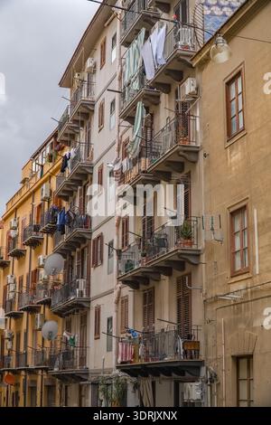 Fassade des Wohngebäudes in Palermo, Sizilien, Italien, mit gestapelten Balkonen mit Wäscheleinen, Satellitenschüsseln und externer Klimaanlage Stockfoto
