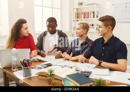 Gruppe von Studenten, die Ideen an einem Tisch in einer Lernsitzung in einem gemeinsamen Bereich diskutieren Stockfoto