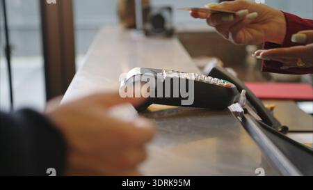 Kunde, der die Zahlung an der Hotelrezeption über das Kreditkartenterminal vornimmt Stockfoto