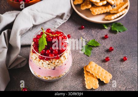 Traditionelles Dessert mit Keksen und roter Johannisbeere in einem Glas auf dem Tisch Stockfoto