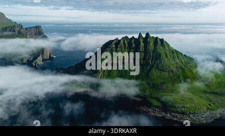 Atemberaubende Aussicht auf zerklüftete Klippen und grüne Landschaften auf den Färöern während der Dämmerung Stockfoto