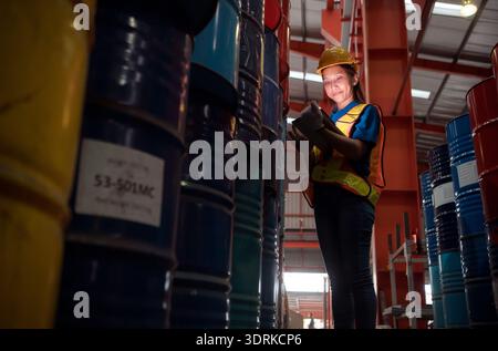 Industriearbeiter, der in einem großen Metallrohr in einer Fabrik mit Schutzhelm inspiziert Stockfoto