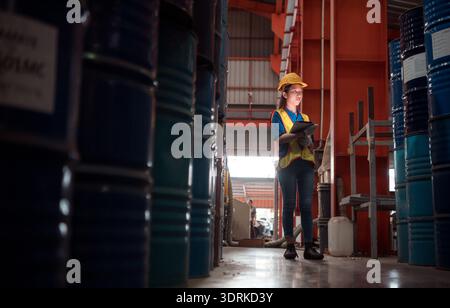 Industriearbeiter, der in einem großen Metallrohr in einer Fabrik mit Schutzhelm inspiziert Stockfoto