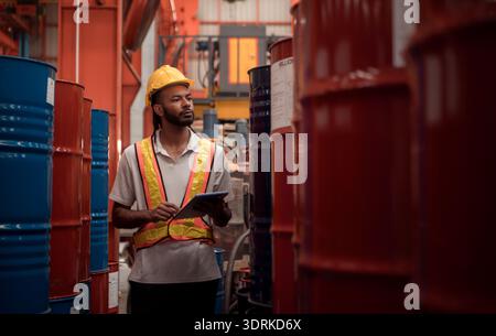 Industriearbeiter, der in einem großen Metallrohr in einer Fabrik mit Schutzhelm inspiziert Stockfoto