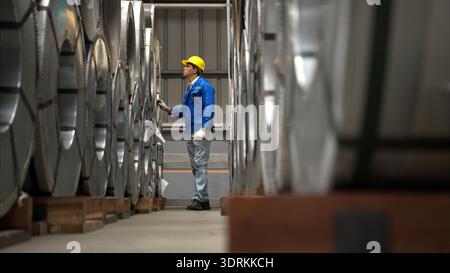 Industriearbeiter, der in einem großen Metallrohr in einer Fabrik inspiziert Stockfoto