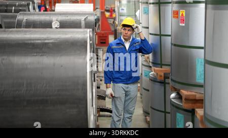 Industriearbeiter, der in einem großen Metallrohr in einer Fabrik inspiziert Stockfoto