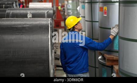 Industriearbeiter, der in einem großen Metallrohr in einer Fabrik inspiziert Stockfoto