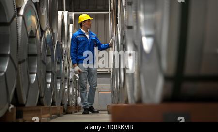 Industriearbeiter, der in einem großen Metallrohr in einer Fabrik inspiziert Stockfoto