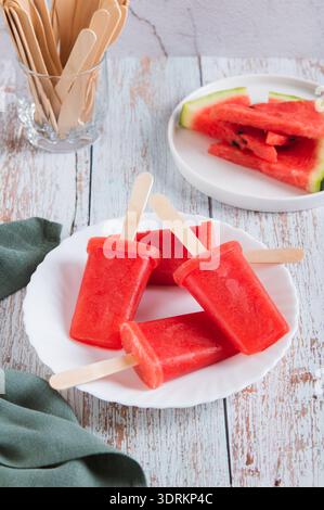 Rote Wassermelonen-Eis auf einem Teller auf dem Tisch, vertikale Ansicht Stockfoto