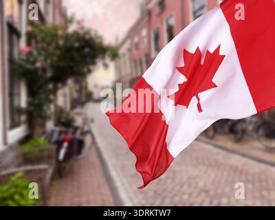 Die Flagge Kanadas winkt auf der Straße. Nationales Symbol Stockfoto