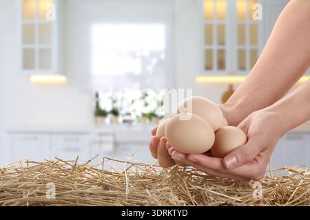 Frau, die Hühnereier in der Küche hält, Nahaufnahme Stockfoto