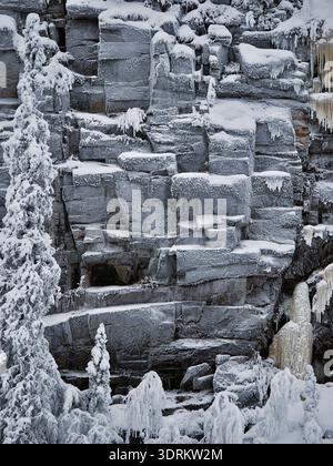 Graue, gefrorene Felsen säumen die Wände des Korouoma Canyon, Finnland, die eine undurchdringliche Barriere darstellen und Gefühle der Leere und Verzweiflung wecken Stockfoto