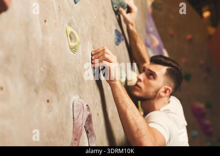 Kletterer arbeiten an einer schwierigen Route in einem Indoor Climbing Gym während der Nachmittagsstunden Stockfoto