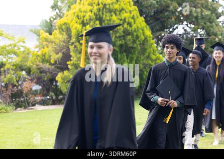 Absolventen in Mützen und Kleidern feiern gemeinsam Erfolge im Freien. Abschluss, Feier, Erfolg, Bildung, Co Stockfoto