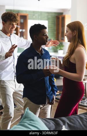 Teenager-Freunde feiern zu Hause, genießen Drinks und lebhafte Gespräche. Party, Freundschaft, Feier, Treffen, b Stockfoto