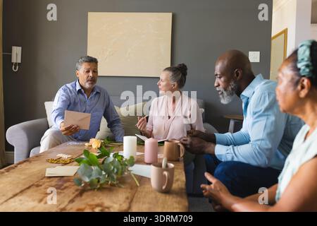 Seniorenfreunde diskutieren zu Hause Pläne, genießen Kaffee und Gespräche zusammen. Freundschaft, Geselligkeit, Bindung, Entspannung Stockfoto
