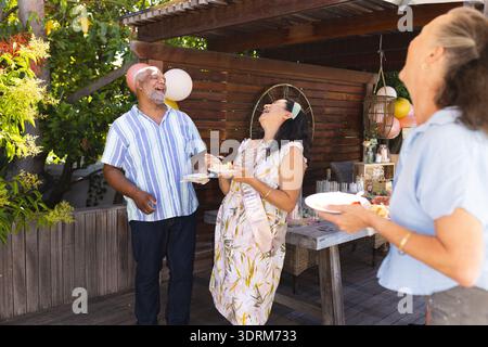 Feiern Sie im Freien, lachen Sie in verschiedenen Gruppen und genießen Sie Kuchen bei festlichen Zusammenkünften. Feier, Vielfalt, Glück, Party, f Stockfoto