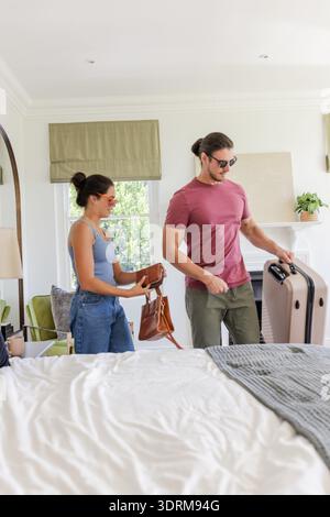 Ein Paar, das mit Gepäck im Hotelzimmer ankommt, bereitet sich auf die Hochzeitsfeier vor. Reisen, Gastfreundschaft, Romantik, Ankunft, Braut Stockfoto