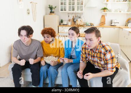Eine Gruppe von Freunden, die sich ein Fußballspiel im fernsehen anschauen. Glückliche Fußballfans feiern zu Hause den Sieg. Freundschaft sp Stockfoto
