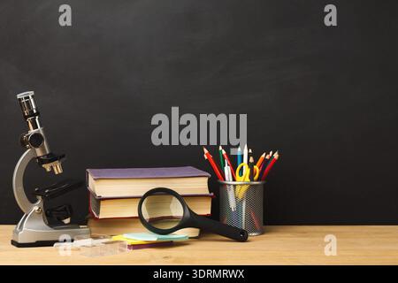 Sammlung von Untersuchungswerkzeugen und -Materialien auf einem Holztisch mit schwarzem Hintergrund Stockfoto