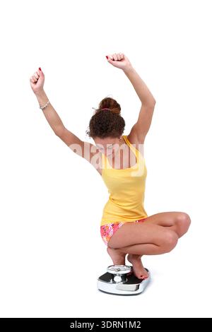 Junge Frau auf der Personenwaage Stockfoto