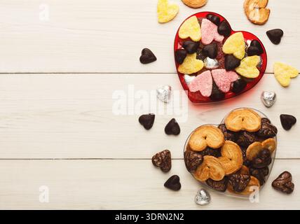 Herzförmige Sammlung von Keksen und Bonbons auf einem Holztisch für süße Anlässe Stockfoto