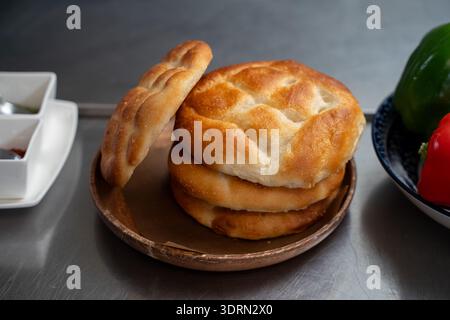 Nahaufnahme von Fladenbrot, gestapelt auf Holzplatte im Innenbereich. Stockfoto