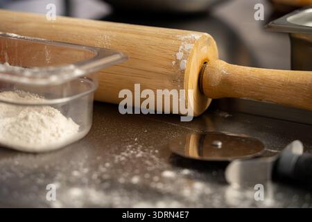 Nahaufnahme von Holzrollstift und Mehl auf der Theke. Stockfoto