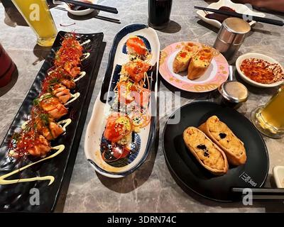 Essen Sie Sushi an einem sonnigen Tag mit fröhlicher Stimmung, frisches Sushi und frischer Lachs auf einem Teller, bereit, mit geliebten Freunden gegessen zu werden Stockfoto