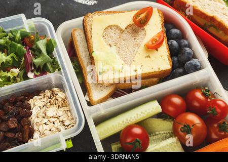 Lunchbox-Set mit verschiedenen Lebensmitteln auf einem Tisch, bereit für eine Mahlzeit oder einen Snack Stockfoto