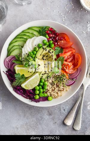 Gesunde vegane Mittagsschale. Avocado, Quinoa, Tomaten, Gurken, Rotkohl, grüne Erbsen und Rettich-Gemüsesalat. Stockfoto