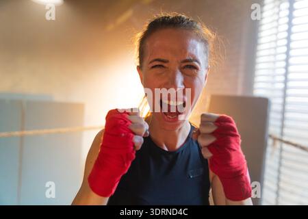 Aufschrei unabhängiger Mädels Macht. Wütende, starke, verrückte Kämpferin, die aggressiv auf Boxring aussieht. Kraftvoll und ehrgeizig Stockfoto