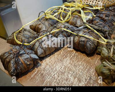 Ein authentischer Zongzi-Reisknödel, in getrocknete Bambusblätter gewickelt und mit Fäden gebunden. Dieser Snack ist ein Grundnahrungsmittel der taiwanesischen Küche und des Tradi Stockfoto