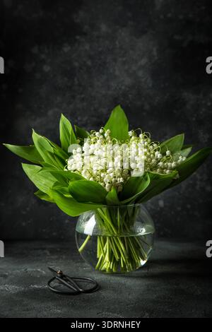 Lily of the Valley blüht in Glasvase Stockfoto