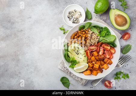 Gesunde vegane Mittagsschale. Avocado, Quinoa, Süßkartoffeln, Tomaten, Spinat und Kichererbsen Gemüsesalat Stockfoto
