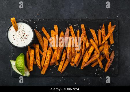 Süßkartoffel mit geräuchertem Paprika serviert mit Knoblauch-Joghurt. Stockfoto