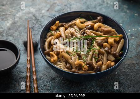 Nudeln mit Huhn und Shimeji-Pilzen in blauer Schüssel Stockfoto