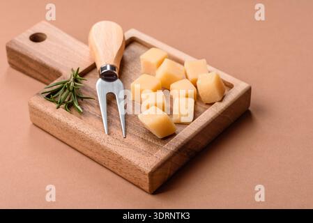 Gewürfelter Cheddar, Gouda oder Parmesankäse auf einem Schneidebrett. Gewürfelter Käse Stockfoto