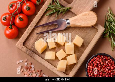 Gewürfelter Cheddar, Gouda oder Parmesankäse auf einem Schneidebrett. Gewürfelter Käse Stockfoto