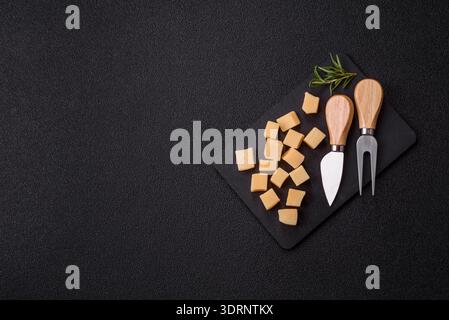 Gewürfelter Cheddar, Gouda oder Parmesankäse auf einem Schneidebrett. Gewürfelter Käse Stockfoto