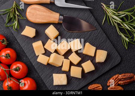 Gewürfelter Cheddar, Gouda oder Parmesankäse auf einem Schneidebrett. Gewürfelter Käse Stockfoto