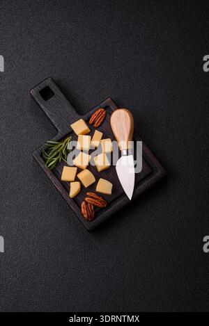 Gewürfelter Cheddar, Gouda oder Parmesankäse auf einem Schneidebrett. Gewürfelter Käse Stockfoto