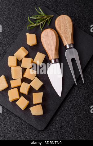 Gewürfelter Cheddar, Gouda oder Parmesankäse auf einem Schneidebrett. Gewürfelter Käse Stockfoto