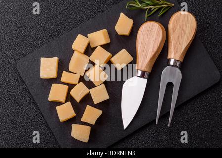 Gewürfelter Cheddar, Gouda oder Parmesankäse auf einem Schneidebrett. Gewürfelter Käse Stockfoto